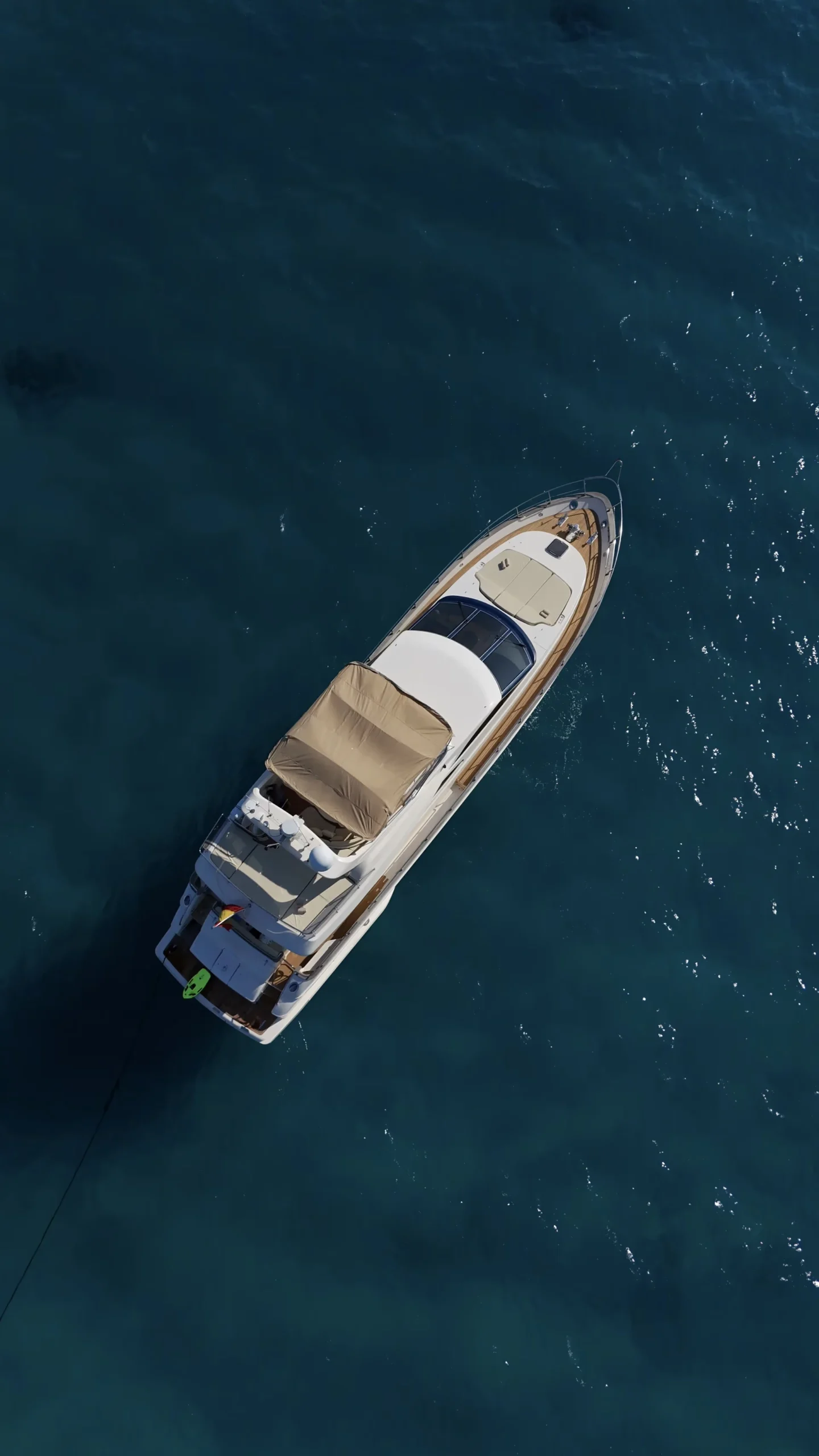 Aerial view of a private yacht cruising clear Mediterranean water in Mallorca